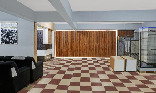 a lobby with a checkered floor and a wooden door at Treebo SLN Heritage in Bengaluru