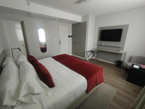 a bedroom with a large bed and a flat screen tv at Guemes Hotel & Spa in Salta