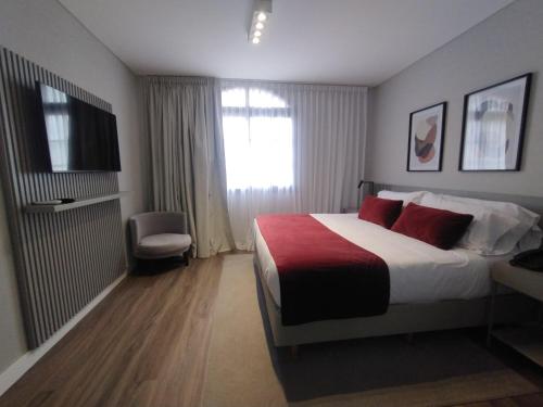 a hotel room with a bed and a television at Guemes Hotel & Spa in Salta