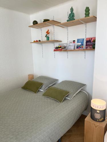 a bedroom with a bed with shelves on the wall at Lovely plage - St François - Mer in Le Havre