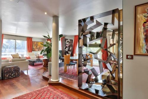 una sala de estar con una gran pared de libros en Appartement grand luxe 180m2, en Neuilly-sur-Seine