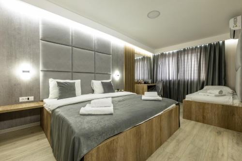 a bedroom with a large bed with towels on it at Kompleks Milosevic in Bijeljina