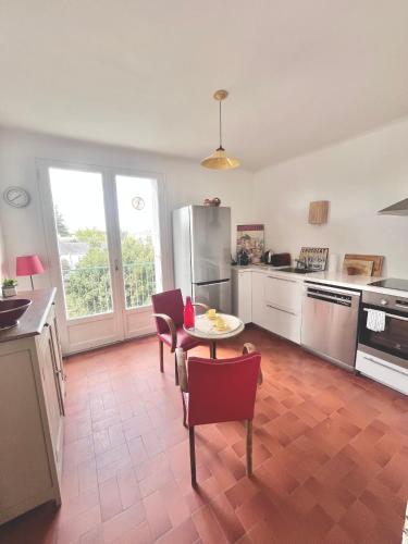 une cuisine avec une table et des chaises dans une pièce dans l'établissement T2 - Procès - parking gratuit - WIFI, à Nantes