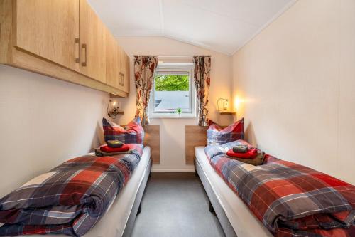 2 Betten in einem kleinen Zimmer mit Fenster in der Unterkunft Haus Ferdi in Koblenz
