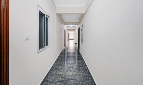a corridor in a house with white walls and a carpeted hallway at Treebo SLN Heritage in Bengaluru