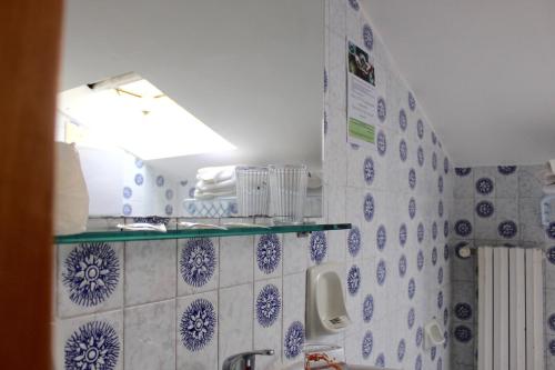 a bathroom with blue and white tiles on the wall at Blue Loft Hotel in Cesenatico