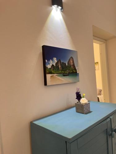 una pintura colgada en una pared con un armario azul en Casa vacanza Sofiu', en Mazara del Vallo