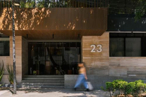 a person walking past a building with the number at Río Nazas 23 by Blueground in Mexico City