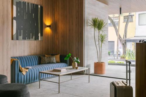 a living room with a blue couch and a table at Río Nazas 23 by Blueground in Mexico City