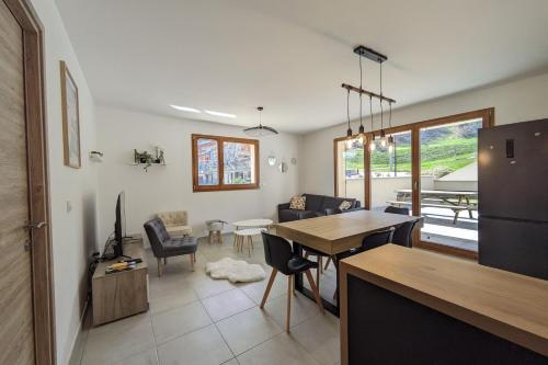 eine Küche und ein Wohnzimmer mit einem Tisch und Stühlen in der Unterkunft Spacieux appartement au pied des pistes in La Feclaz