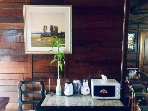 einen Tisch mit einer Mikrowelle und ein Bild an der Wand in der Unterkunft Kribi Trip Experience in Kribi