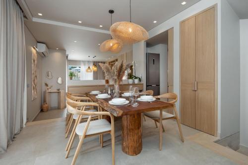 a dining room with a wooden table and chairs at Foneas Bay Villa in Proástion