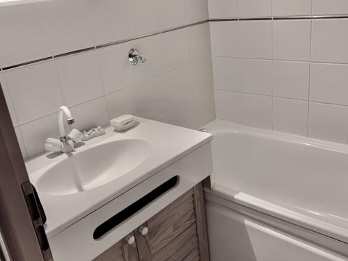 La salle de bains blanche est pourvue d'un lavabo et d'une baignoire. dans l'établissement Appartement 2 Pièces à Châtel - 4 Pers, Terrasse, 500m des Remontées, Parking, Connexion Internet - FR-1-676-61, à Châtel