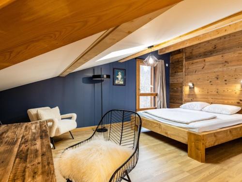 une chambre avec un lit et une chaise dans une pièce dans l'établissement Spacieux Appartement 4 Chambres avec Wi-Fi et Garage aux Gets - FR-1-671-252, aux Gets