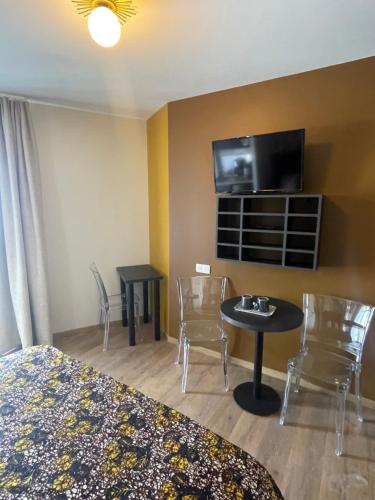 ル・アーヴルにあるSmart Appart Le Havre 105のベッド、テーブル、椅子が備わるホテルルームです。