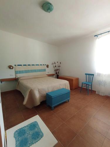 a bedroom with a bed and two blue chairs at Da Nonno Francesco in Teulada