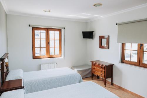 a bedroom with two beds and a desk and window at Casa Veiga in Valdoviño