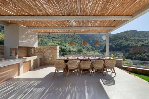 a kitchen and dining room with a table and chairs at Foneas Bay Villa in Proástion