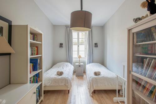 a small room with two beds and bookshelves at Maison De Charme En Bourgogne in Saint-Gengoux-le-National