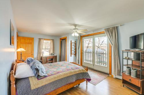 a bedroom with a bed and a tv and a balcony at Waterfront Hampden Home on Hermon Pond! in Hampden