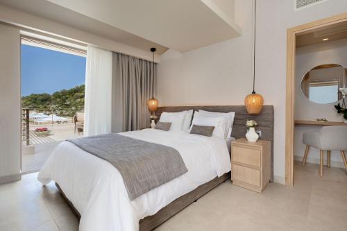 1 dormitorio con 1 cama grande y balcón en Foneas Bay Villa, en Proástion