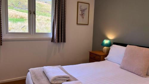 een slaapkamer met een bed en een raam bij Skye in Oban