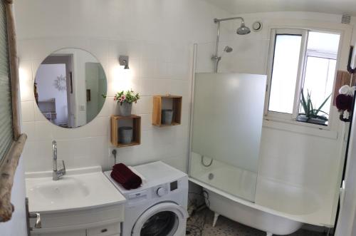 La salle de bains blanche est pourvue d'un lavabo et d'un lave-linge. dans l'établissement Pura Vida Bayonne, à Bayonne
