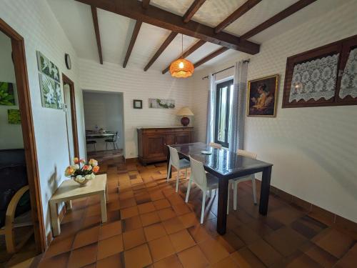 une salle à manger avec une table et des chaises noires dans l'établissement Maison Brissac, à Brissac