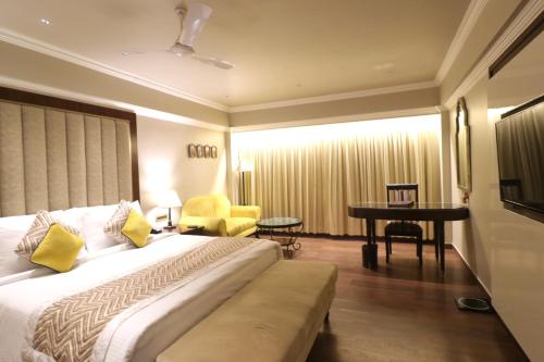 a hotel room with a bed and a piano at Hotel Swosti Premium Bhubaneswar in Bhubaneshwar