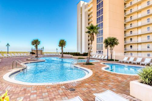 a swimming pool with palm trees and a building at Lake Town Wharf in Panama City Beach