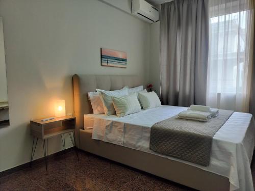 um quarto com uma cama grande e um candeeiro. em Nefeli -1BR Lux Apartment - Tsimiski Ladadika - Explore Center by foot - Close to Aristotelous square em Tessalônica
