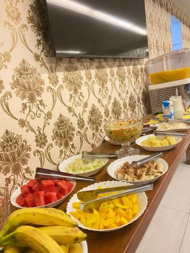 a buffet with many plates of fruits and vegetables at Hotel Central Campo Grande in Campo Grande