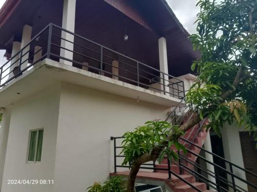 a balcony of a house with a tree at White Win Villa in Elewala