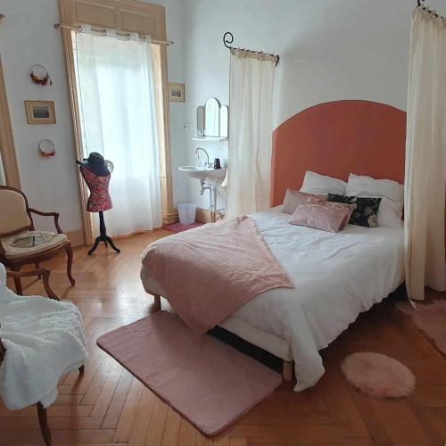 une chambre avec un grand lit et une chaise dans l'établissement La Petite Porte Verte, à Bouilland