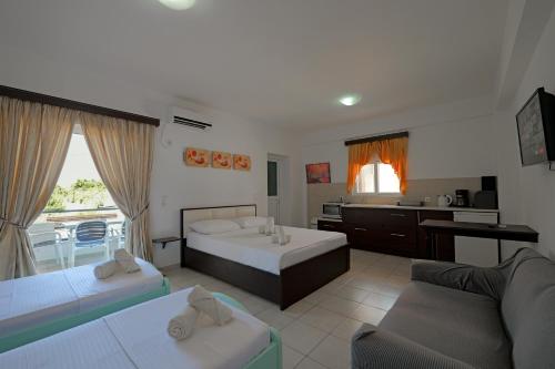 a living room with two beds and a kitchen at Livia's Guesthouse in Ksamil