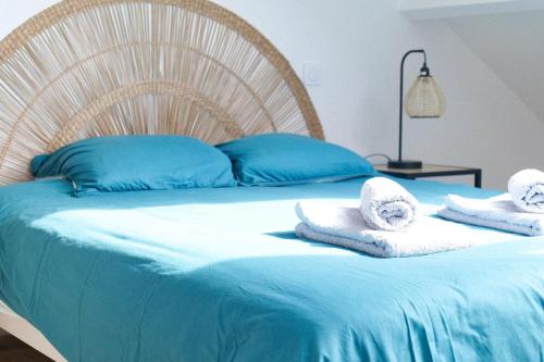 - un lit avec des serviettes et des oreillers dans l'établissement Belle maison rénovée avec goût proche village Vendée Globe, Les Sables 8 pers, à Les Sables-dʼOlonne