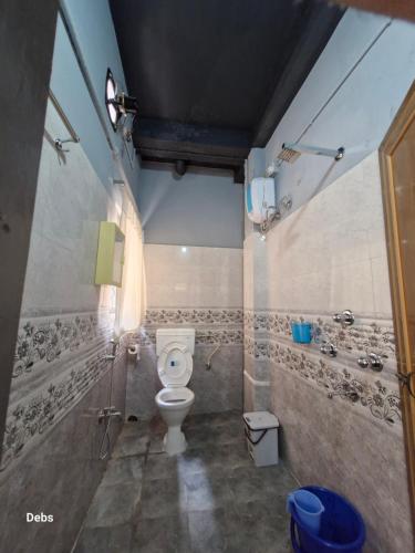 a bathroom with a toilet and a shower at FAITH in Siliguri