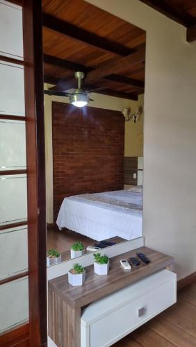 a bedroom with a bed with potted plants on a table at Chalé 06 com hidro in Itatiaia