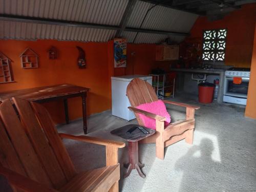 eine Küche mit einem Holzstuhl und einem Tisch in der Unterkunft Hostal claire in El Quije