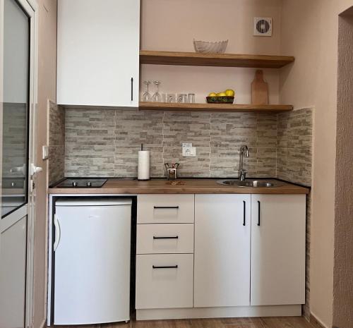 een keuken met witte kasten en een wastafel bij Abazovic Apartments in Ulcinj