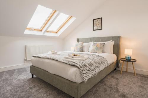 a bedroom with a large bed with a skylight at Beautifully done 5 bed barn conversion in Heswall - Sleeps up to 10 in Heswall