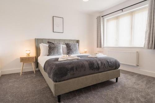 a bedroom with a large bed and a window at Beautifully done 5 bed barn conversion in Heswall - Sleeps up to 10 in Heswall