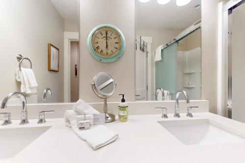 uma casa de banho com dois lavatórios e um grande relógio na parede em Modern Gem in Gypsum em Eagle