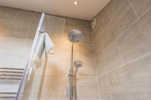 a shower with two shower heads in a bathroom at Beautifully done 5 bed barn conversion in Heswall - Sleeps up to 10 in Heswall