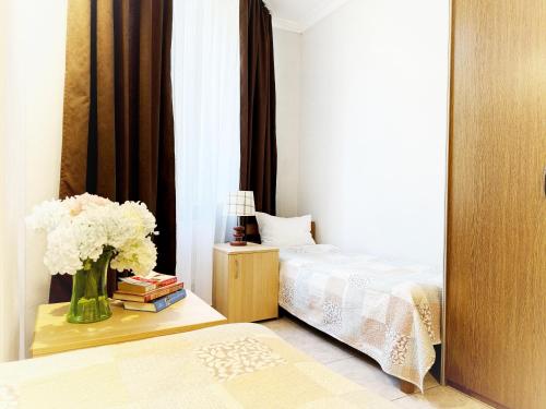 a bedroom with a bed and a vase of flowers on a table at SIGNEEV'S Villa in Kyiv