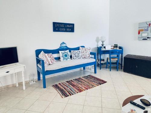 a living room with a blue bench and a table at Dapia Holiday Home in Spetses