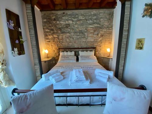Cama grande en habitación con pared de piedra en Garda Paradise Country House, en Lonato