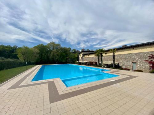 a large swimming pool next to a brick building at Garda Paradise Country House in Lonato del Garda