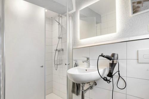 a white bathroom with a sink and a shower at Rügenferienhaus Gartenwohnung in Schaprode
