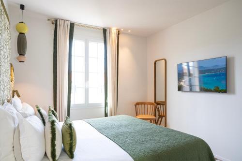 una camera con un letto e una grande finestra di Lou Cagnard a Saint-Tropez